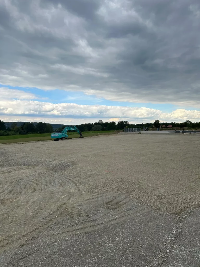 Großflächiges Planum für einen Reitplatz mit Bagger im Hintergrund